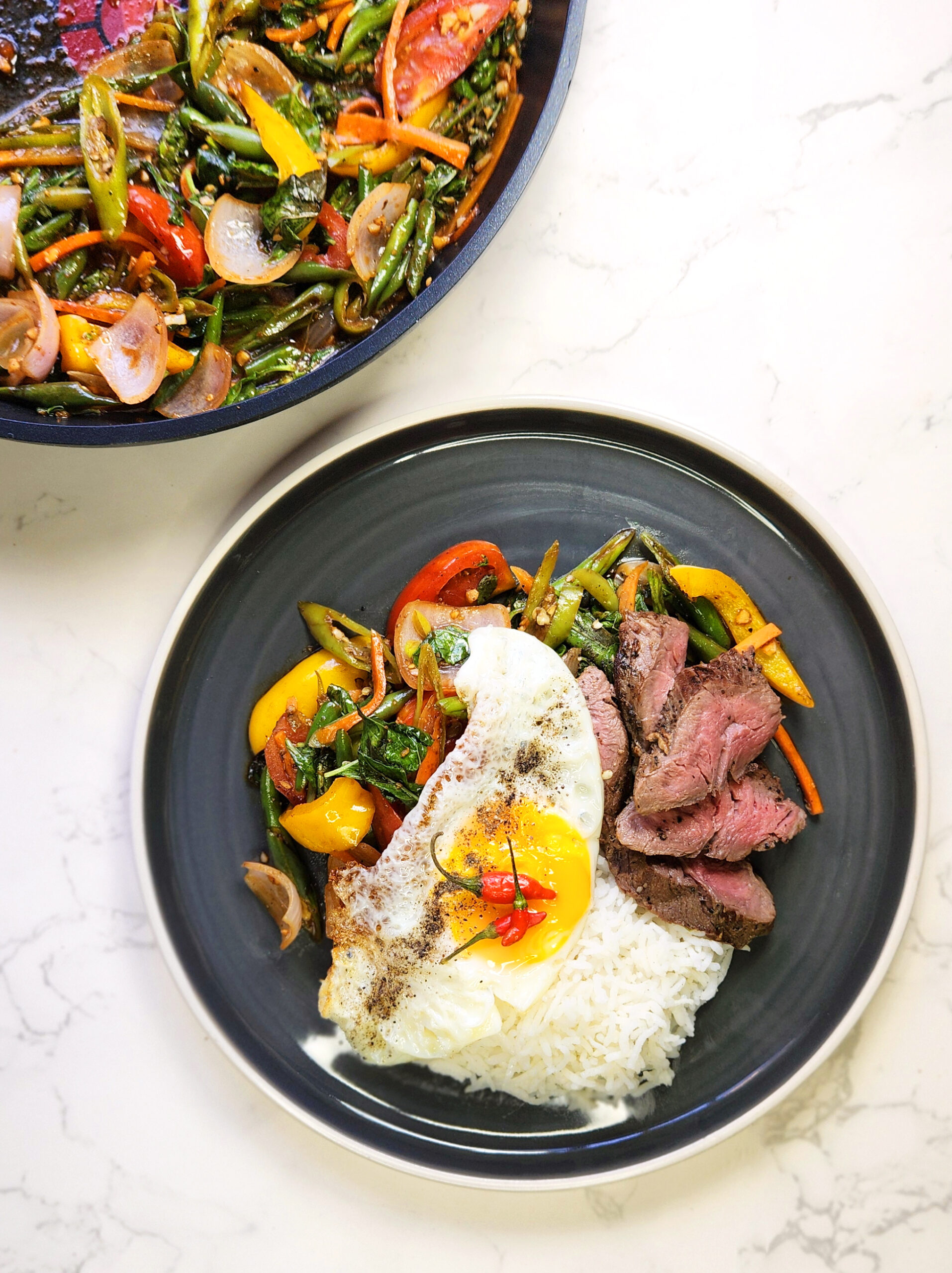 thai chilli basil steak on a plate with a fried egg