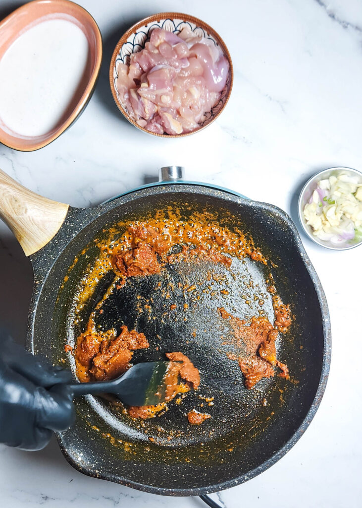 khow suey _ ingredients - spice mix being fried in a pan